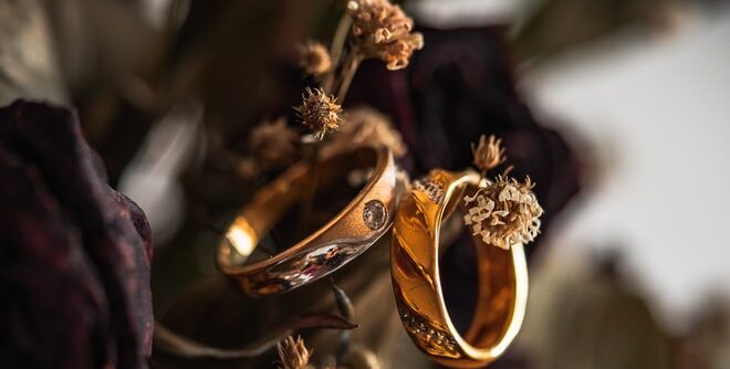 gold wedding band on brown leaves